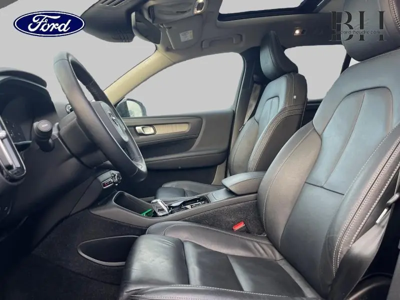 Intérieur noir du Volvo XC40 D3 Inscription Luxe, vue côté gauche sur les sièges avant en cuir et le volant.