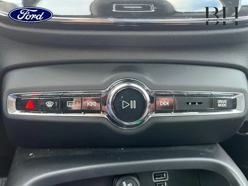 Panneau de commandes central noir avec boutons multimédia et mode de conduite du Volvo XC40 D3 noir, vue rapprochée.