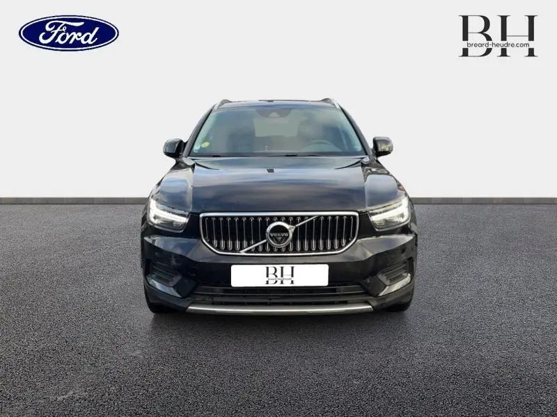 Vue frontale d'un Volvo XC40 noir avec calandre verticale et phares LED distinctifs sur fond neutre.