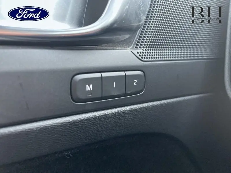 Boutons de réglage mémoire des sièges sur la porte intérieure noire d'un Volvo XC40 D3 noir, vue rapprochée côté conducteur.