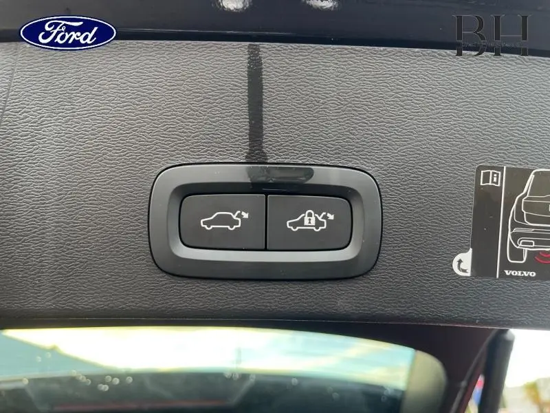 Boutons de commande d'ouverture et verrouillage du coffre sur le hayon intérieur d'un Volvo XC40 noir, vue rapprochée.