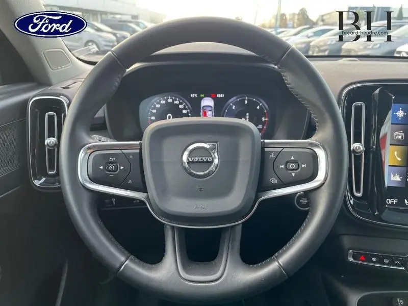 Vue rapprochée du volant cuir noir du Volvo XC40 D3 Inscription Luxe avec commandes intégrées et tableau de bord numérique.
