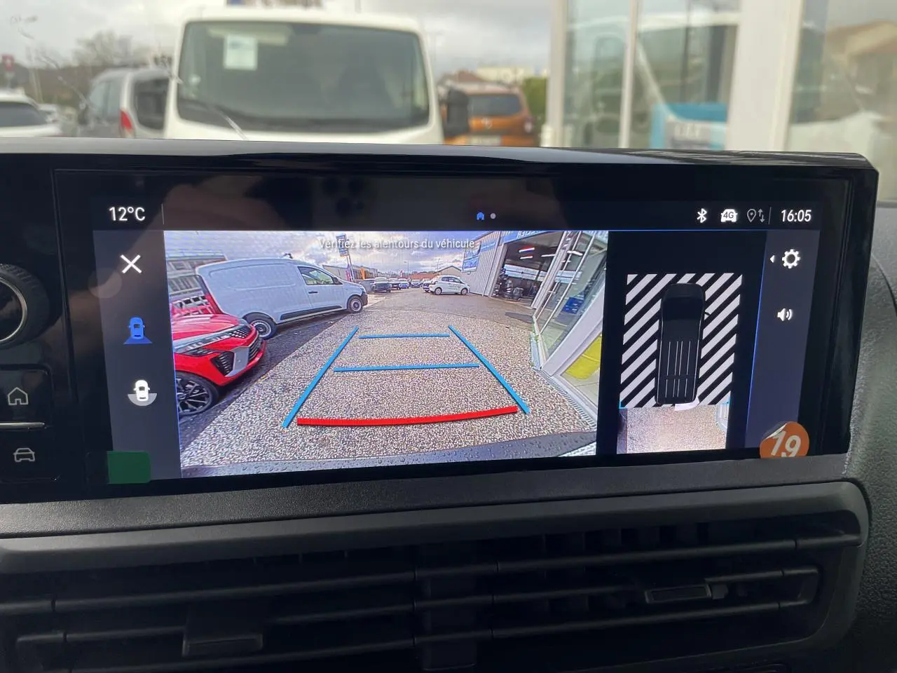 Écran tactile intérieur montrant la caméra de recul 180° du fourgon blanc Opel Vivaro, vue arrière avec guidage.