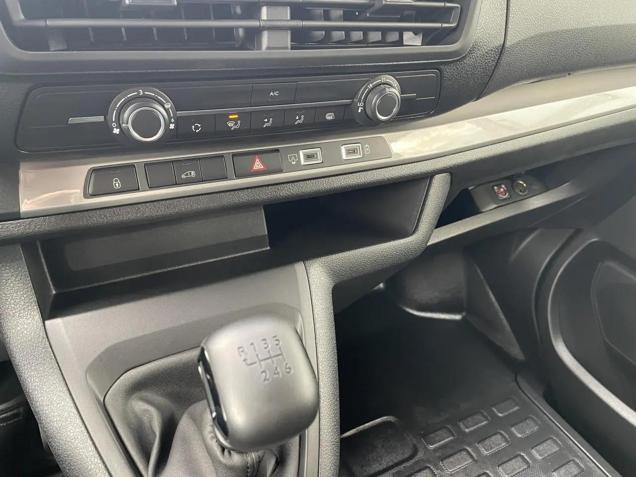 Intérieur Opel Vivaro 2024 vue côté passager, console centrale avec levier de vitesses manuel et commandes climatisation.