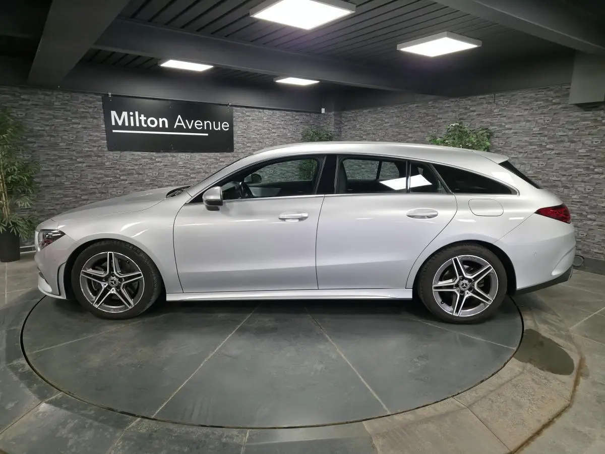 Vue de profil côté gauche d'une Mercedes CLA Shooting Brake gris métallisé avec jantes AMG cinq branches.