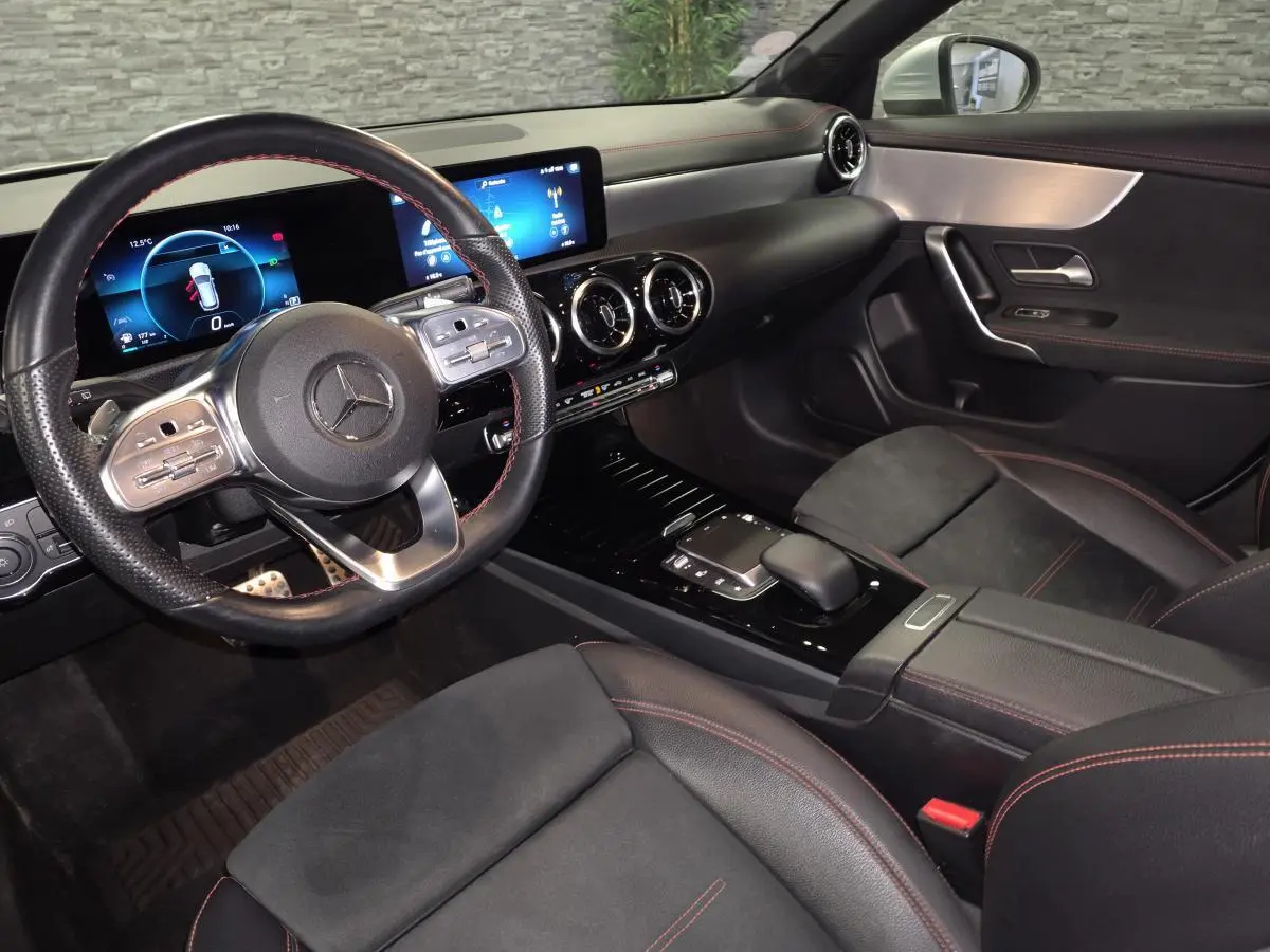 Vue intérieure côté conducteur de la Mercedes CLA Shooting Brake AMG Line 2020 avec sellerie noire et surpiqûres rouges.