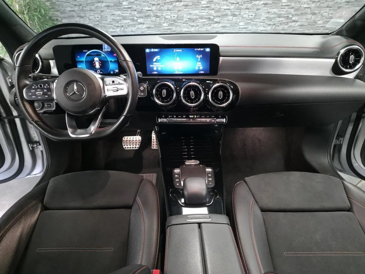 Vue intérieure avant de la Mercedes Classe CLA Shooting Brake 200 AMG Line 2020, tableau de bord noir avec écran digital et volant sport cuir.