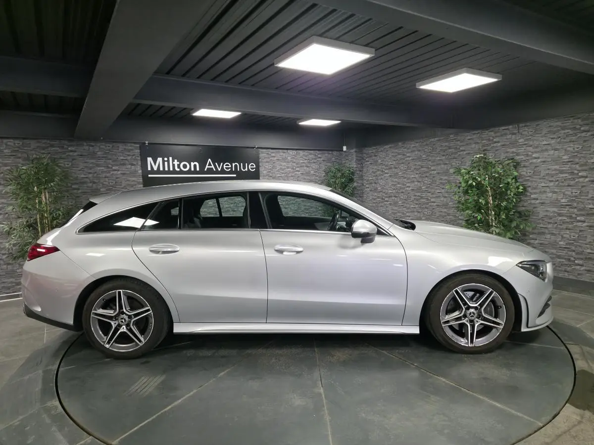 Vue latérale droite d'une Mercedes Classe CLA Shooting Brake 200 AMG Line gris métallisé, avec jantes alliage AMG cinq branches.