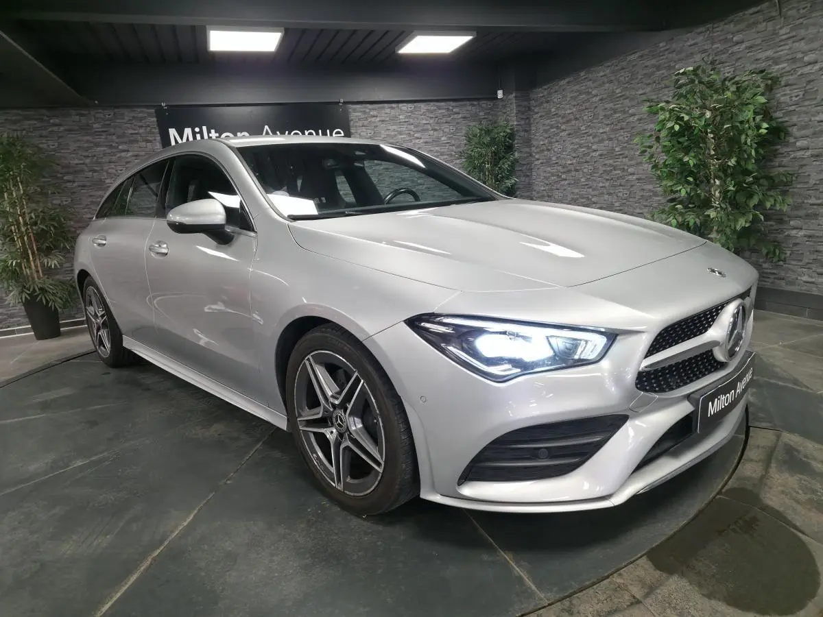 Vue 3/4 avant droite d'une Mercedes CLA Shooting Brake gris métallisé avec calandre diamant et jantes AMG cinq branches.