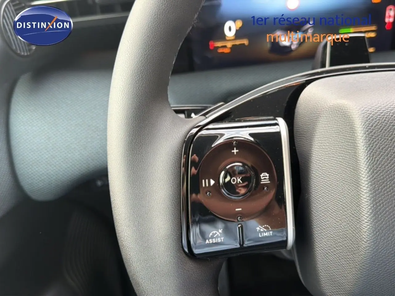 Gros plan sur les commandes au volant du Citroën C5 Aircross Hybrid gris platinium, avec boutons de régulateur et limiteur.