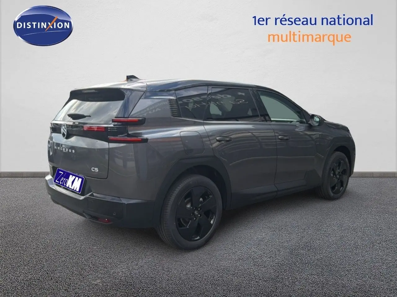 Vue 3/4 arrière droite d'un Citroën C5 Aircross Hybrid gris platinium avec jantes noires et feux arrière horizontaux.