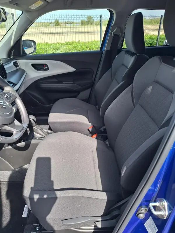 Vue intérieure côté conducteur de la Suzuki Swift 2025 bleu, sièges tissu gris et volant multifonction.