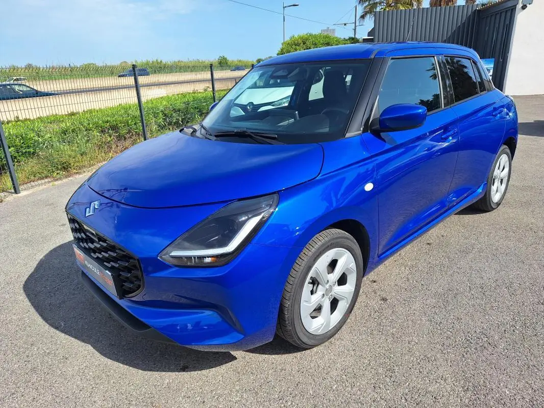 Suzuki Swift 1.2 Hybrid bleu en 3/4 avant droit, avec jantes alliage 16 pouces et feux LED distinctifs.