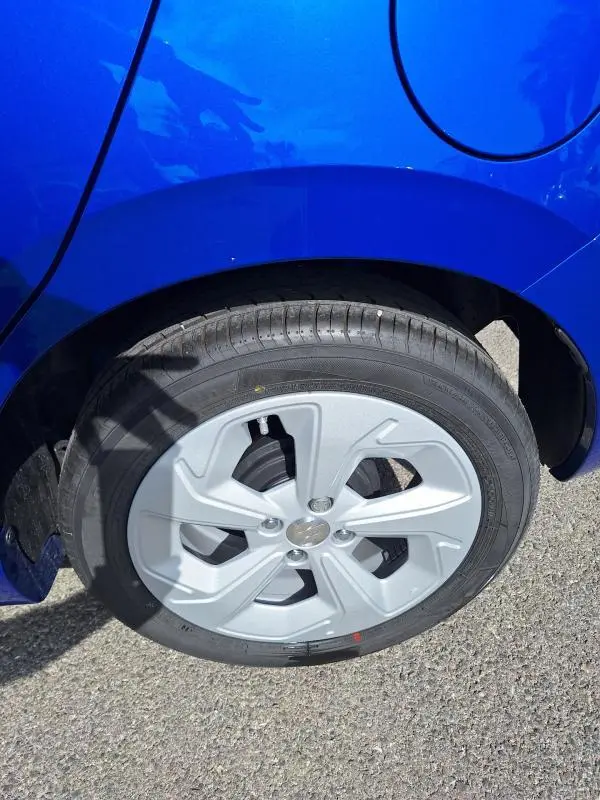 Gros plan sur la roue arrière droite d'une Suzuki Swift 2025 bleu avec jante alliage 16 pouces.