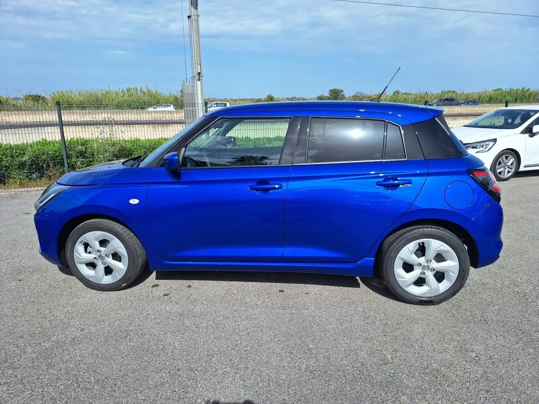 Profil côté gauche d'une Suzuki Swift 2025 bleu vif avec jantes alliage et toit noir contrasté.