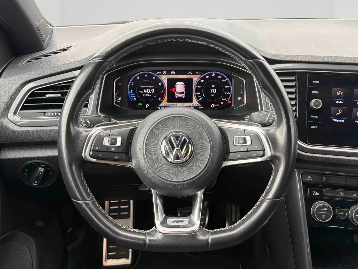 Vue intérieure centrée sur le volant cuir multifonctions R-Line et le tableau de bord digital du Volkswagen T-Roc 2020.