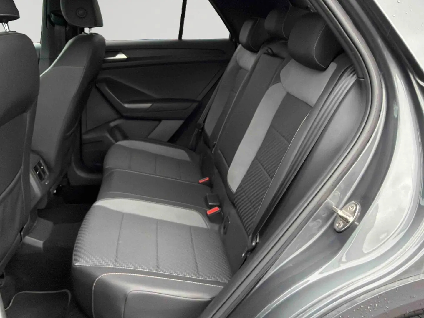 Vue côté droit de l'intérieur arrière du Volkswagen T-Roc gris Indium, sièges en similicuir et tissu gris foncé.