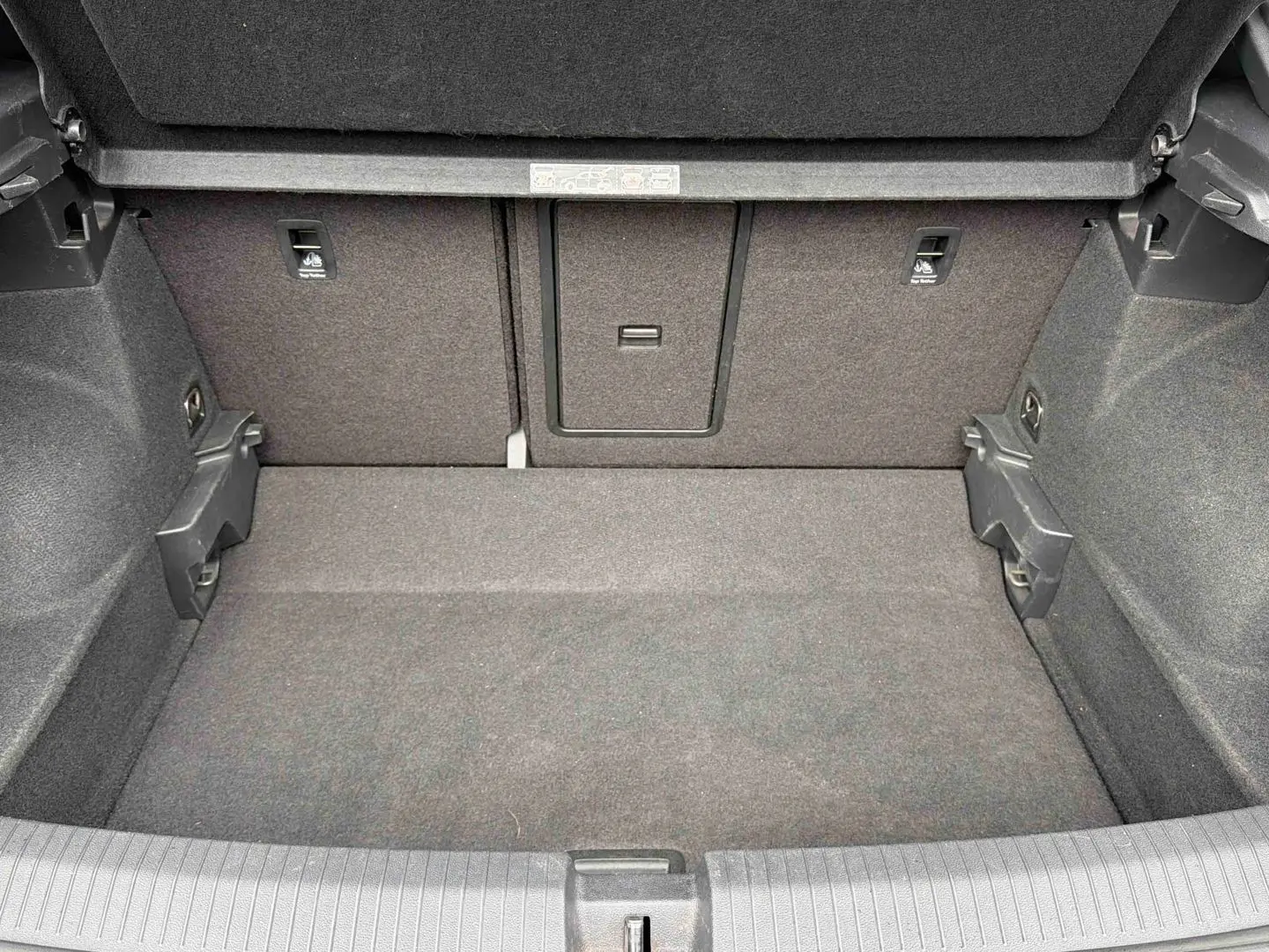 Coffre ouvert vu de l'arrière d'un Volkswagen T-Roc 2020, revêtement intérieur gris foncé uniforme.