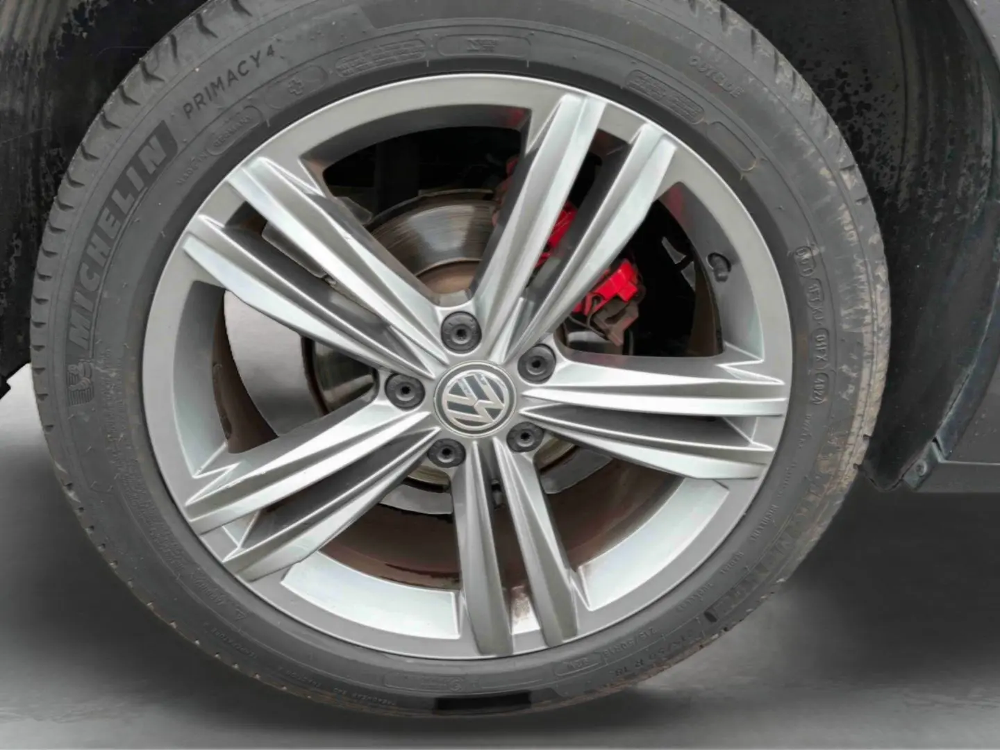 Gros plan sur la jante alliage 18 pouces Nevada gris indium métal du Volkswagen T-Roc avec étrier de frein rouge visible.