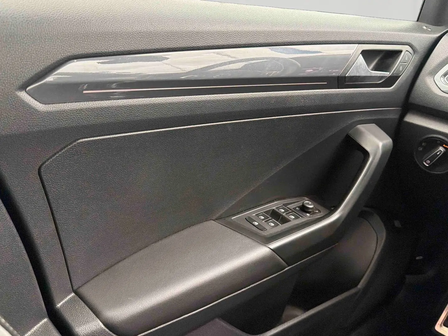 Vue rapprochée de la porte avant gauche du Volkswagen T-Roc 2020, avec accoudoir en similicuir et commandes électriques.