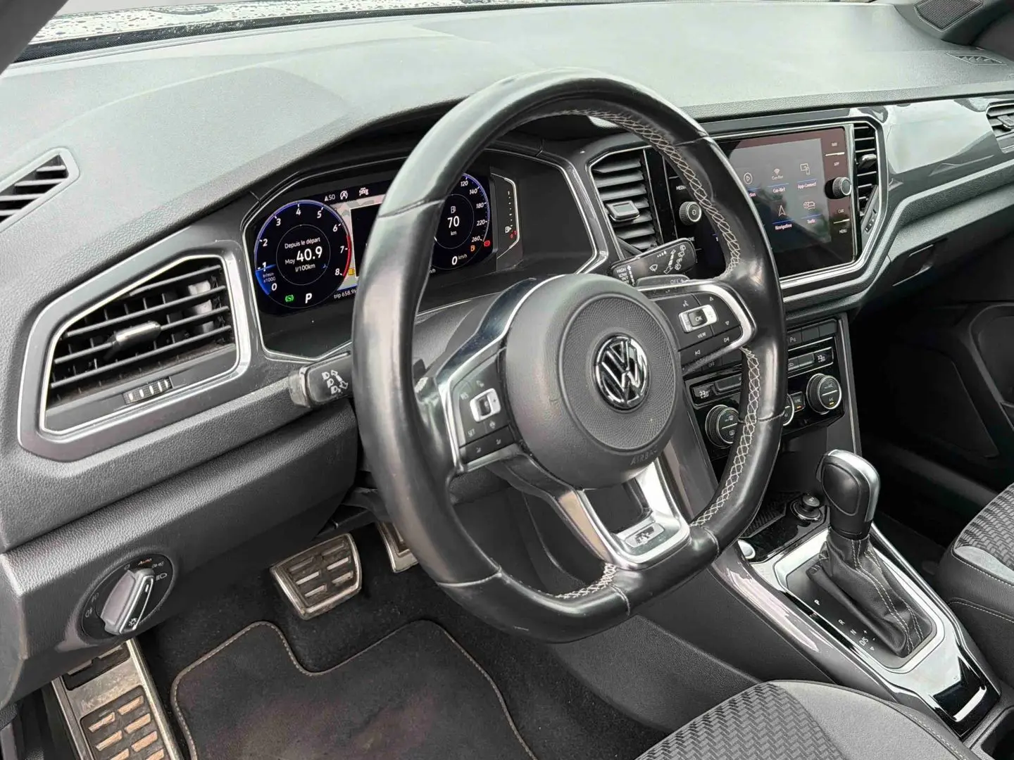 Vue intérieure centrée sur le volant cuir multifonctions et le tableau de bord digital du Volkswagen T-Roc gris Indium.
