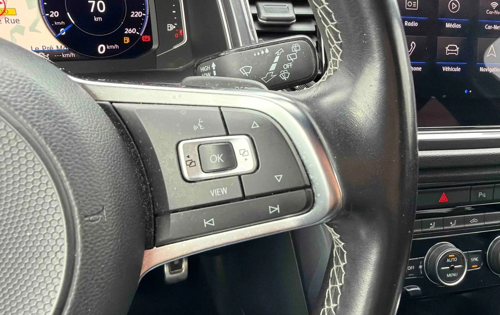 Vue rapprochée du volant cuir multifonctions et du tableau de bord digital du Volkswagen T-Roc gris Indium 2020.