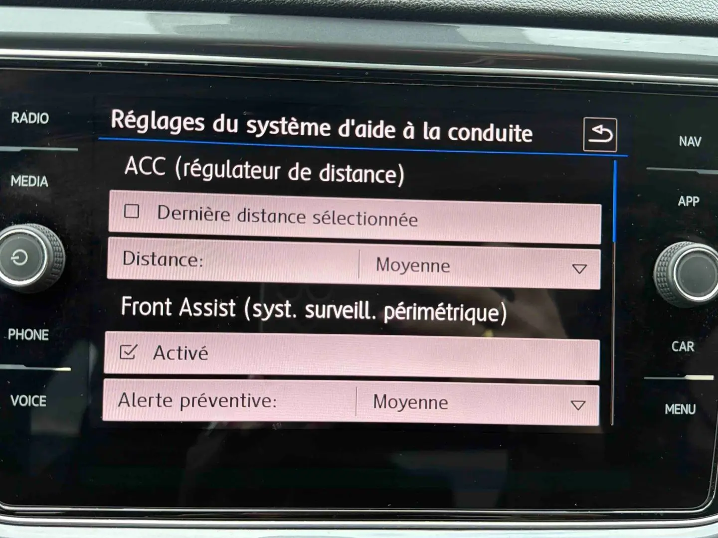 Écran tactile du système d'infodivertissement Volkswagen affichant les réglages d'aide à la conduite ACC et Front Assist.