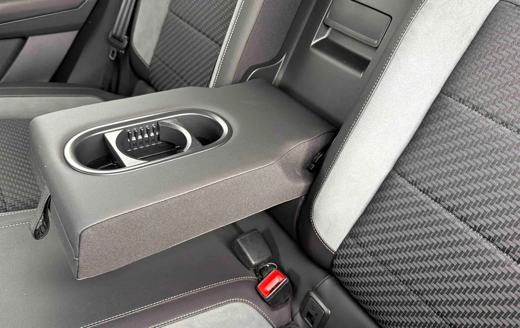 Gros plan sur l'accoudoir central arrière en similicuir gris avec porte-gobelets du Volkswagen T-Roc 2020.