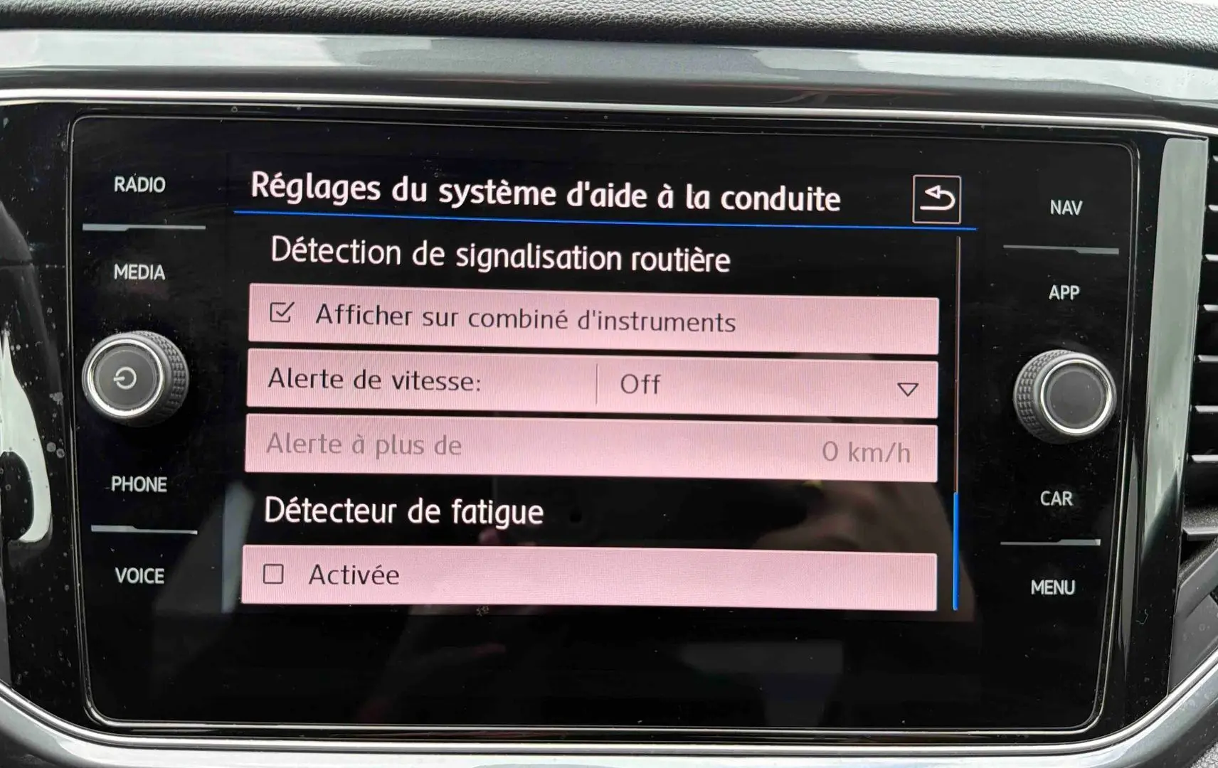 Écran tactile intérieur du Volkswagen T-Roc affichant les réglages d'aide à la conduite, vue de face.