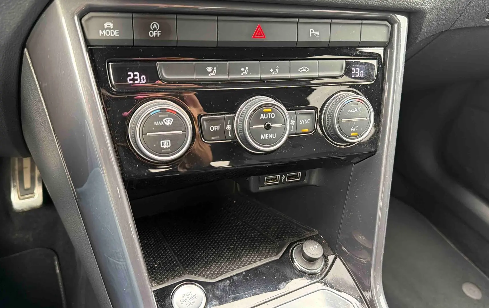 Vue rapprochée de la console centrale noire brillante du Volkswagen T-Roc 2020 avec commandes de climatisation et ports USB.