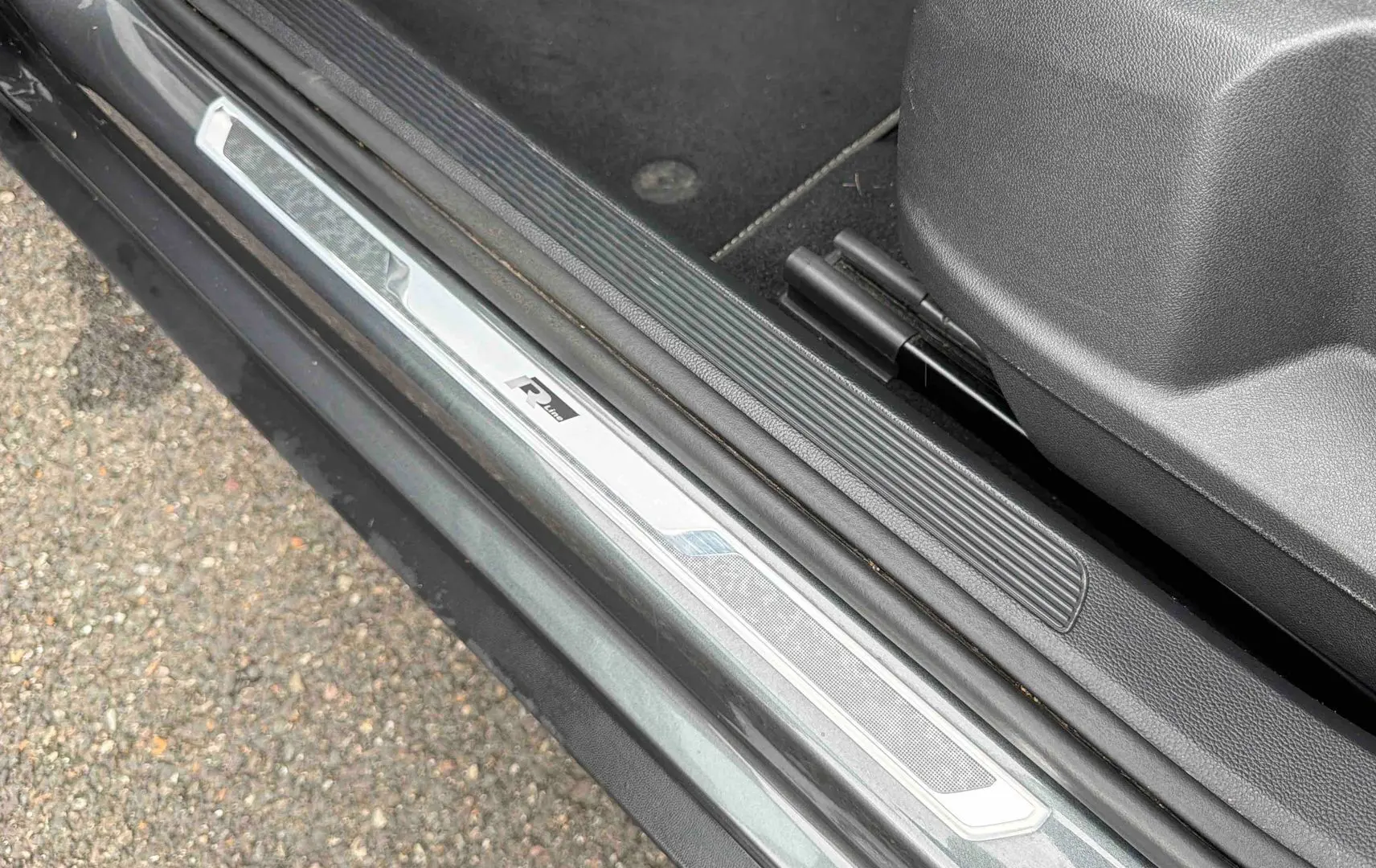 Gros plan sur la plaque de seuil de porte côté gauche du Volkswagen T-Roc gris Indium avec logo R-Line.
