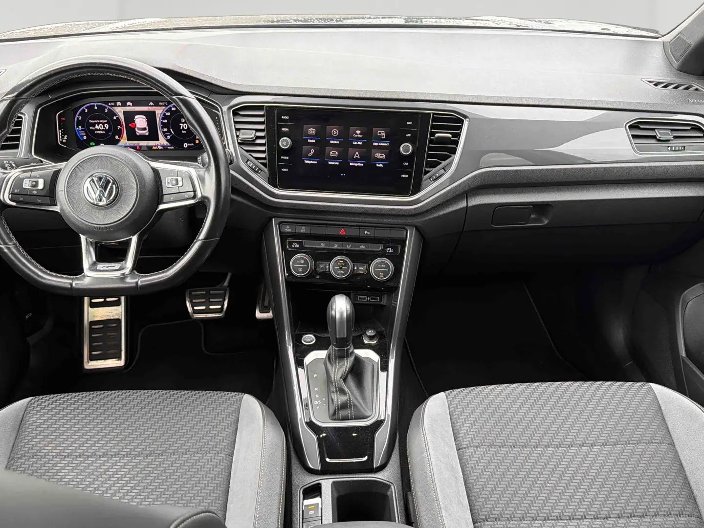 Vue intérieure frontale du tableau de bord et console centrale noire du Volkswagen T-Roc 2020 avec volant cuir multifonctions.