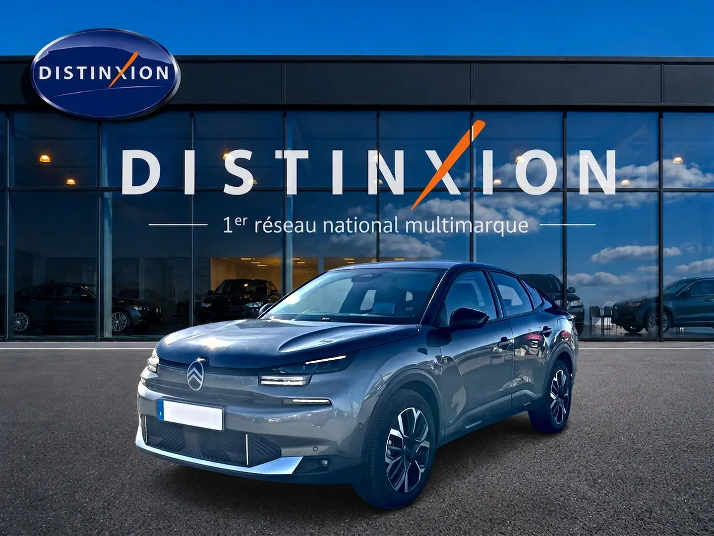 Citroën C4 X gris mercure en 3/4 avant droit devant une vitrine avec logo Distinxion.