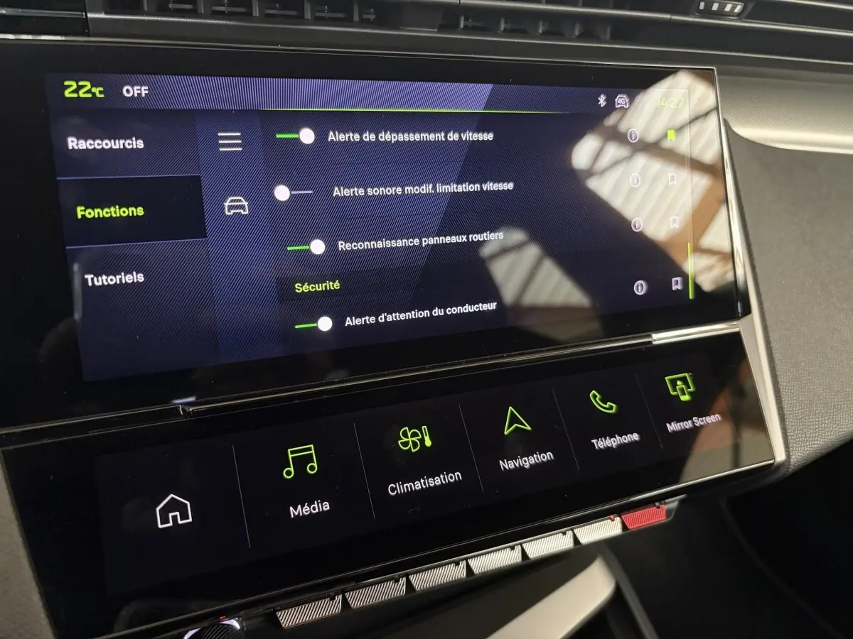 Écran tactile central de la Peugeot 308 Hybrid 2025 affichant les réglages d'alerte et navigation, vue intérieure frontale.