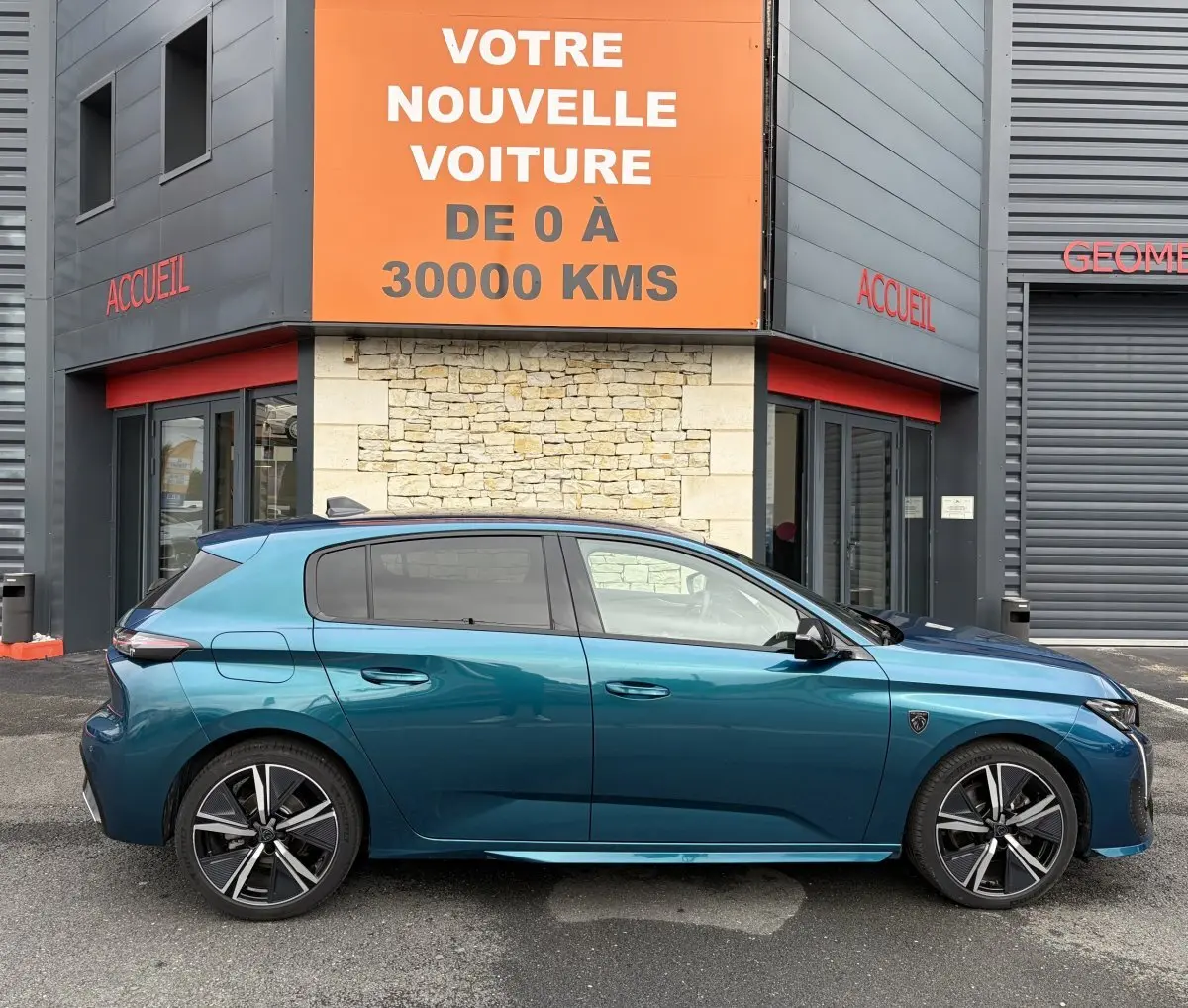 Profil côté gauche d'une Peugeot 308 hybride 2025 bleu métallisé, avec jantes alliage et vitres teintées.