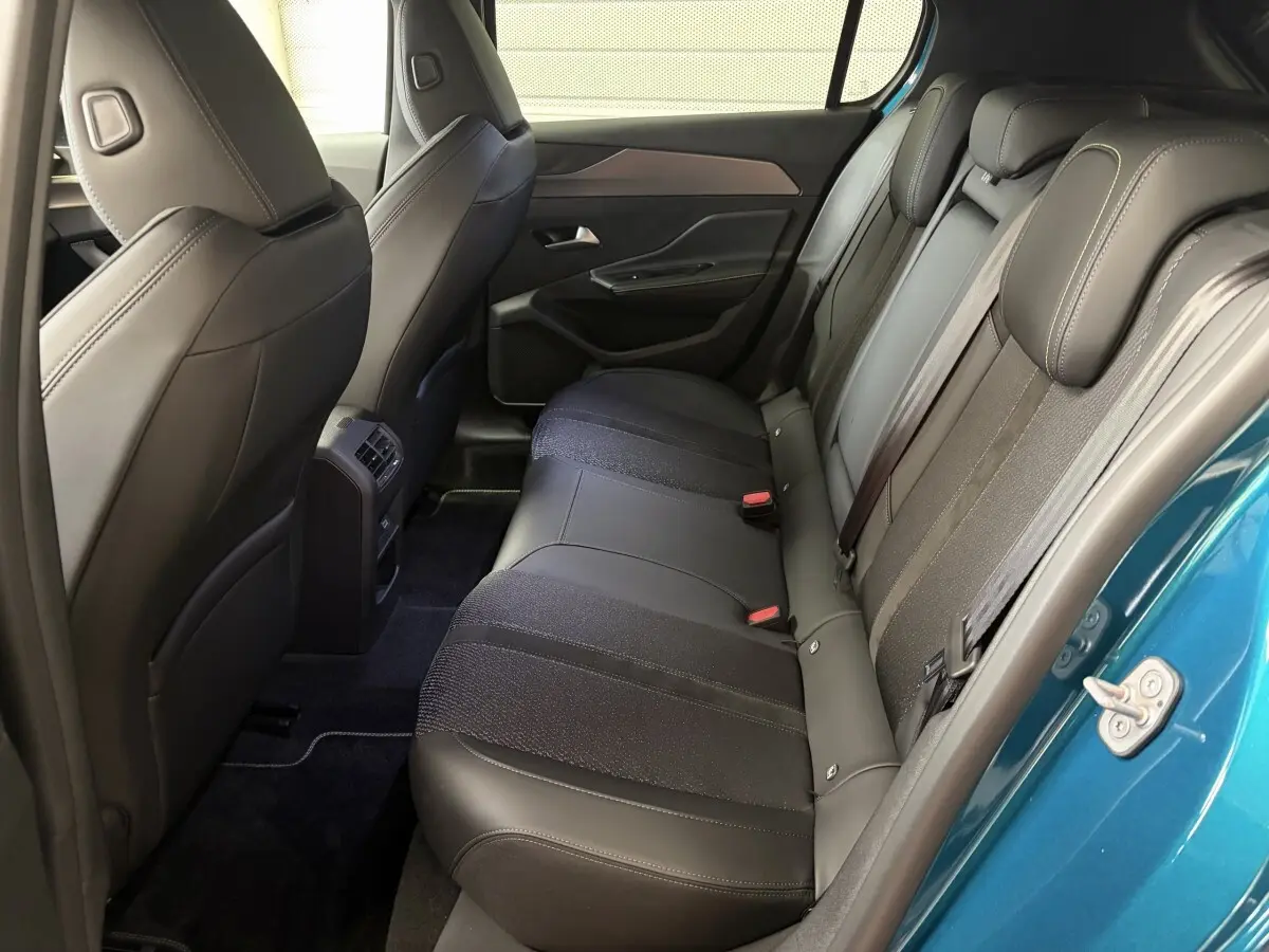 Vue intérieure côté droit des sièges arrière en cuir noir de la Peugeot 308 1.2 Hybrid 145 GT bleu 2025.