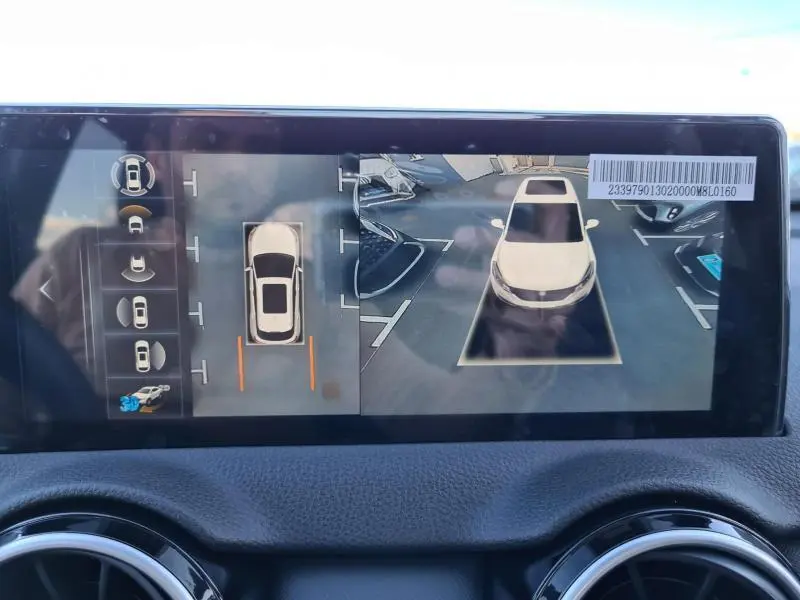 Vue écran intérieur du système d'aide au stationnement 360° du SERES 3 rouge carmin, affichant la voiture vue de dessus et de face.