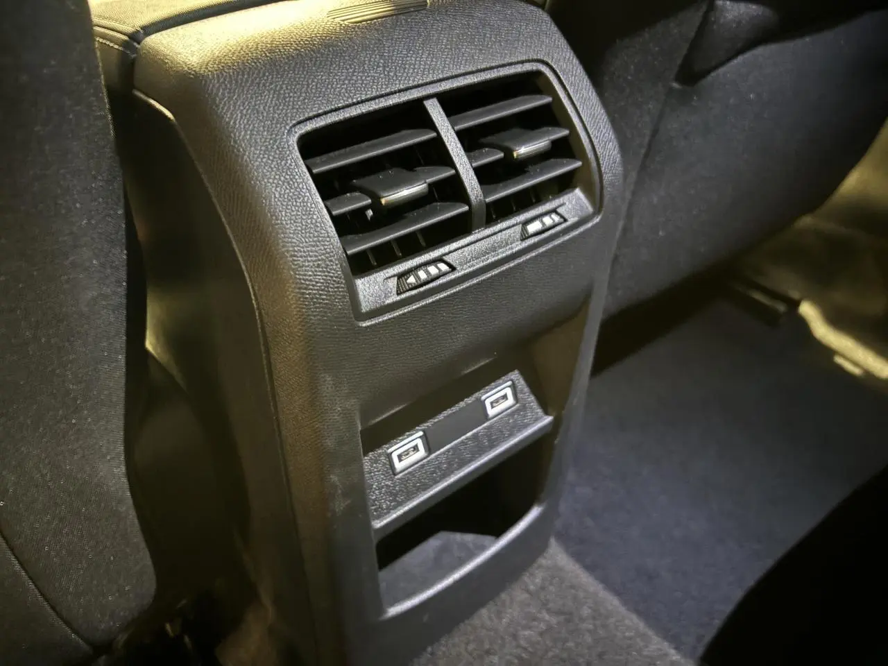 Vue rapprochée des aérateurs arrière et des deux prises USB C sur la console centrale d'une Peugeot 308 SW gris clair.