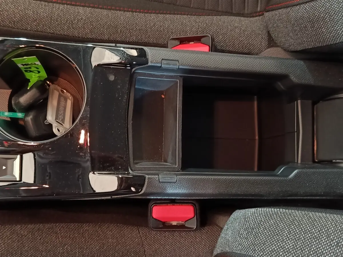 Vue plongeante sur la console centrale noire et les sièges gris foncé de la Peugeot 208 Electrique Active Business.