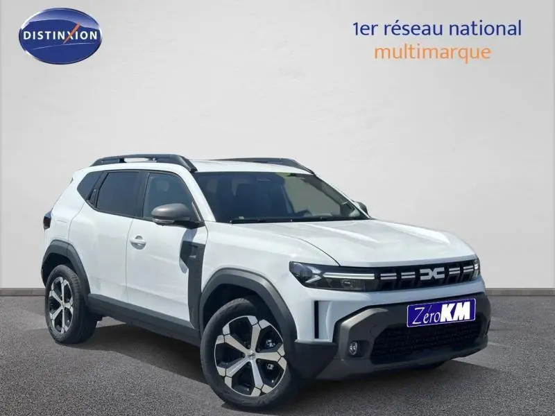 Vue 3/4 avant d'un Dacia Duster blanc Glacier 2025 avec jantes alu et barres de toit noires.