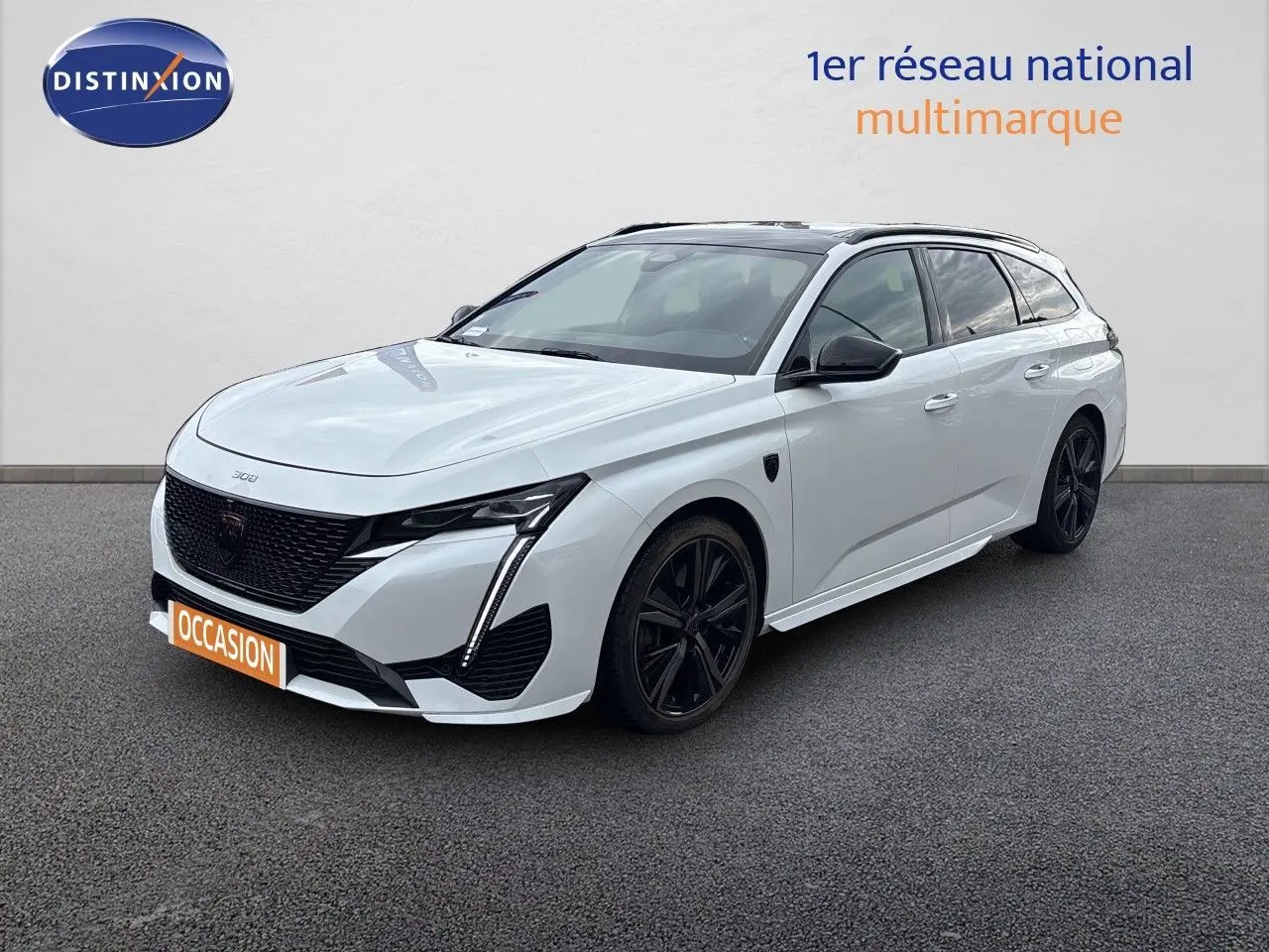 Peugeot 308 SW hybride blanc nacré, vue 3/4 avant droit, jantes noires et calandre noire distinctive.