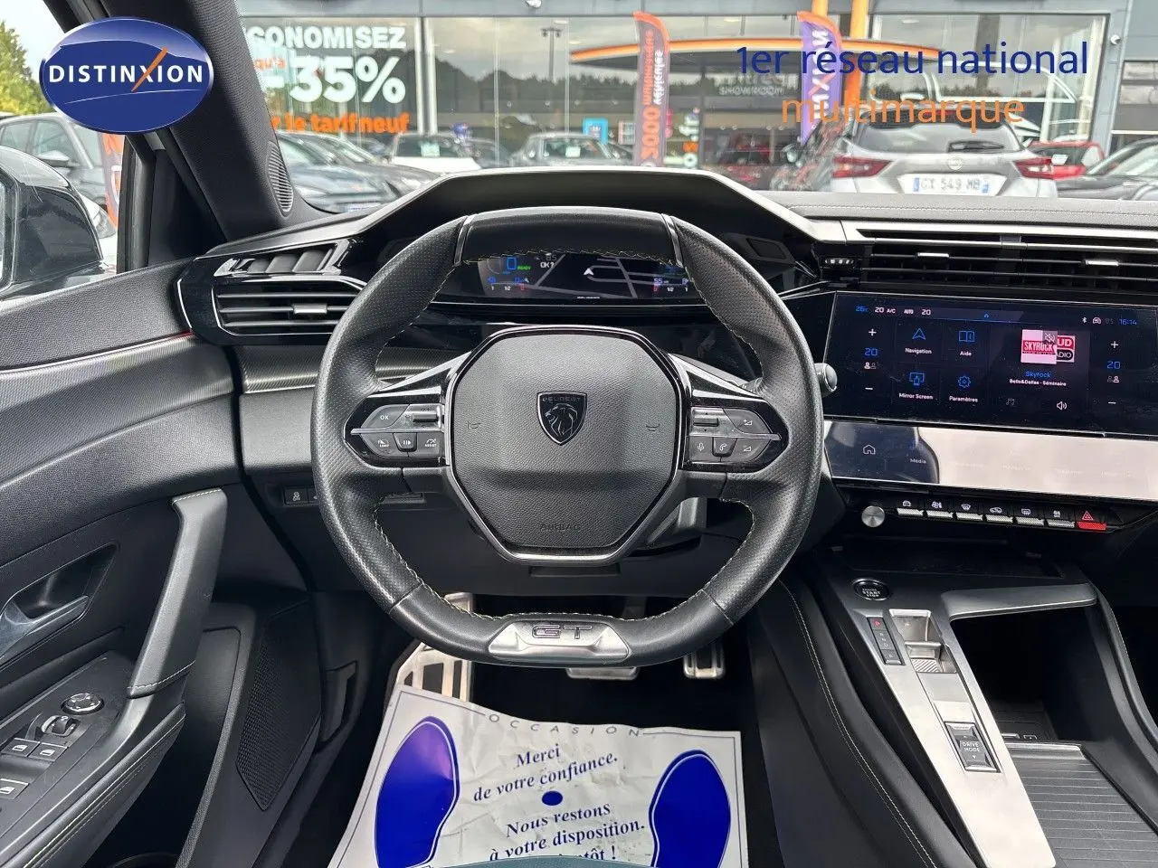 Vue intérieure centrée sur le volant cuir GT et le tableau de bord numérique de la Peugeot 308 SW hybride 2022.