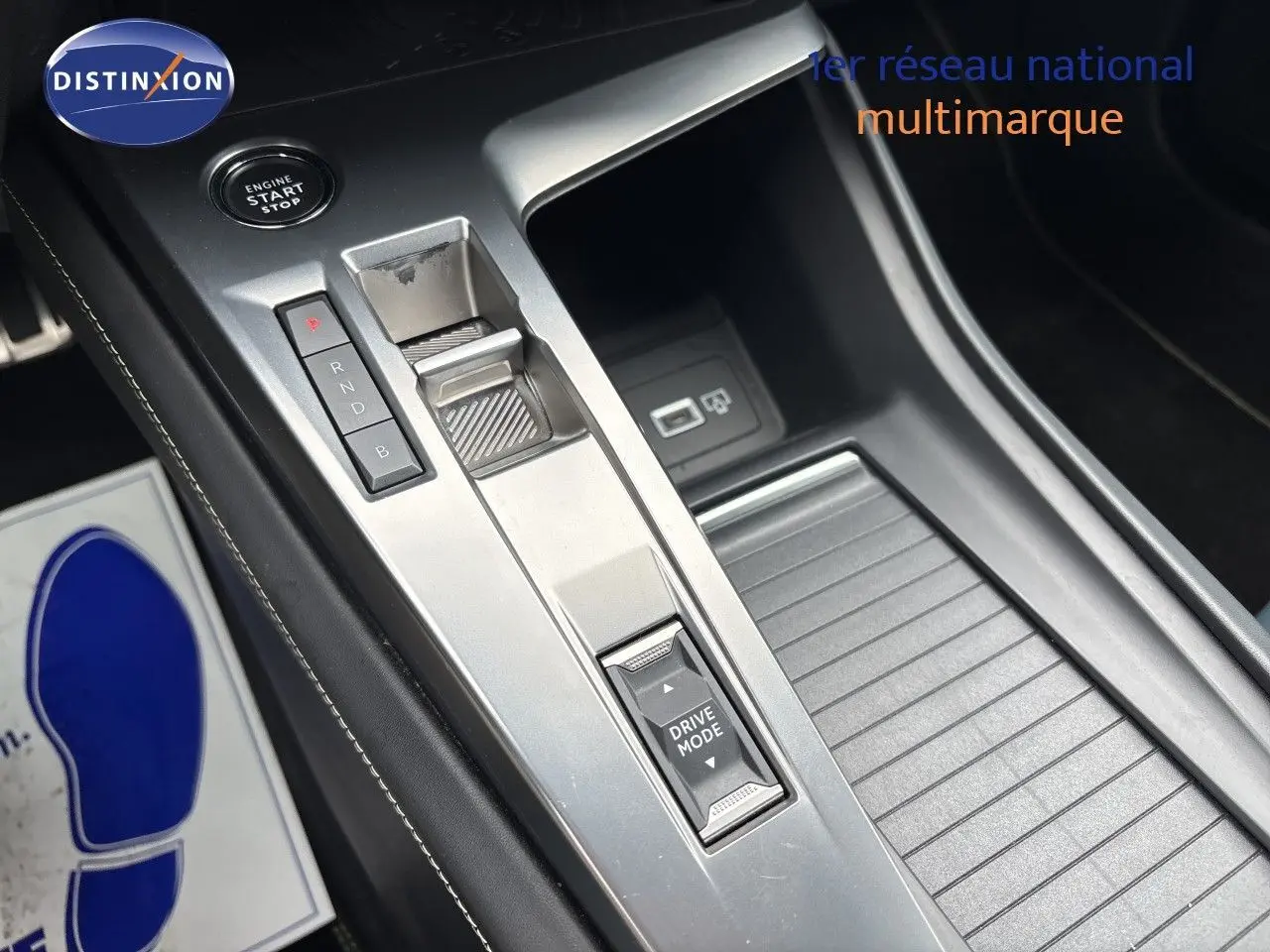 Gros plan sur la console centrale argentée de la Peugeot 308 SW hybride 2022 avec commandes de boîte auto et bouton Drive Mode.