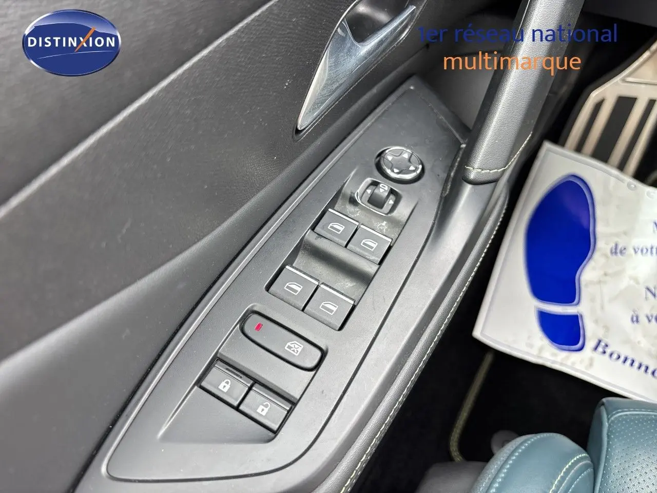 Gros plan sur la commande des vitres et des rétroviseurs côté conducteur d’une Peugeot 308 SW Hybride blanche.