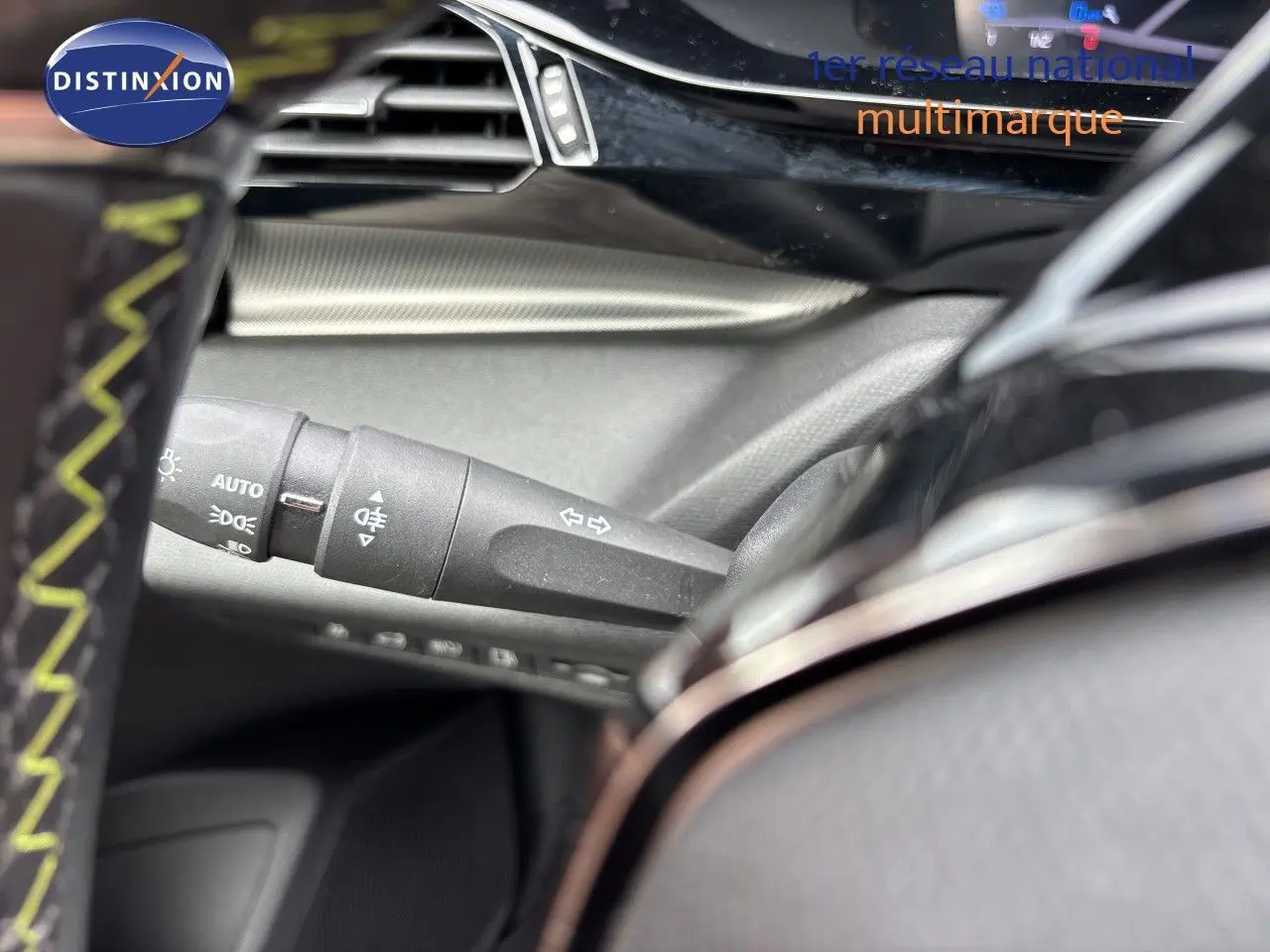 Gros plan sur la commande des clignotants et feux, intérieur noir du Peugeot 308 SW hybride blanc nacré 2022.