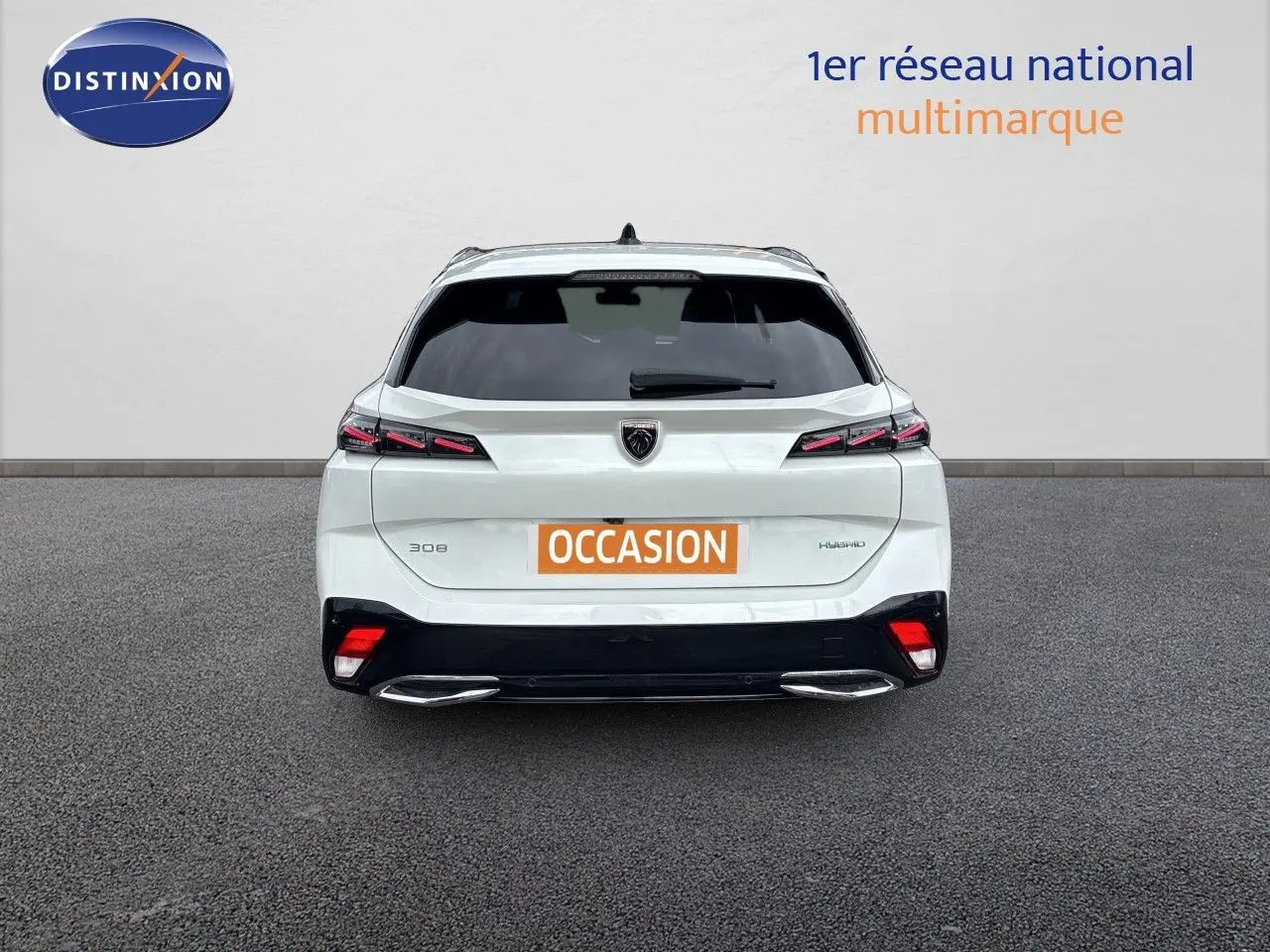 Vue arrière d'une Peugeot 308 SW hybride blanche nacrée avec feux LED et double sortie d'échappement chromée.