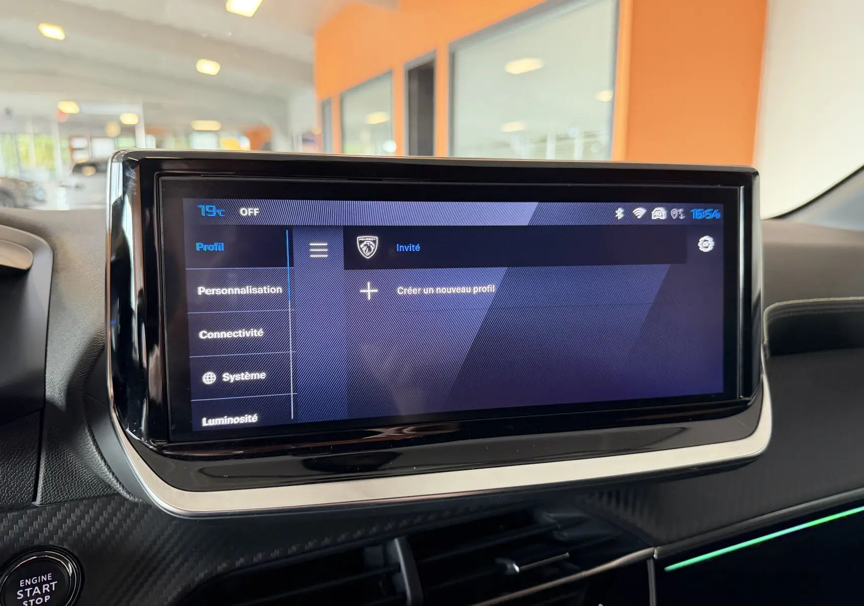 Écran tactile central de la Peugeot 208 Hybrid 145 GT, affichant le menu profil dans un intérieur moderne noir.