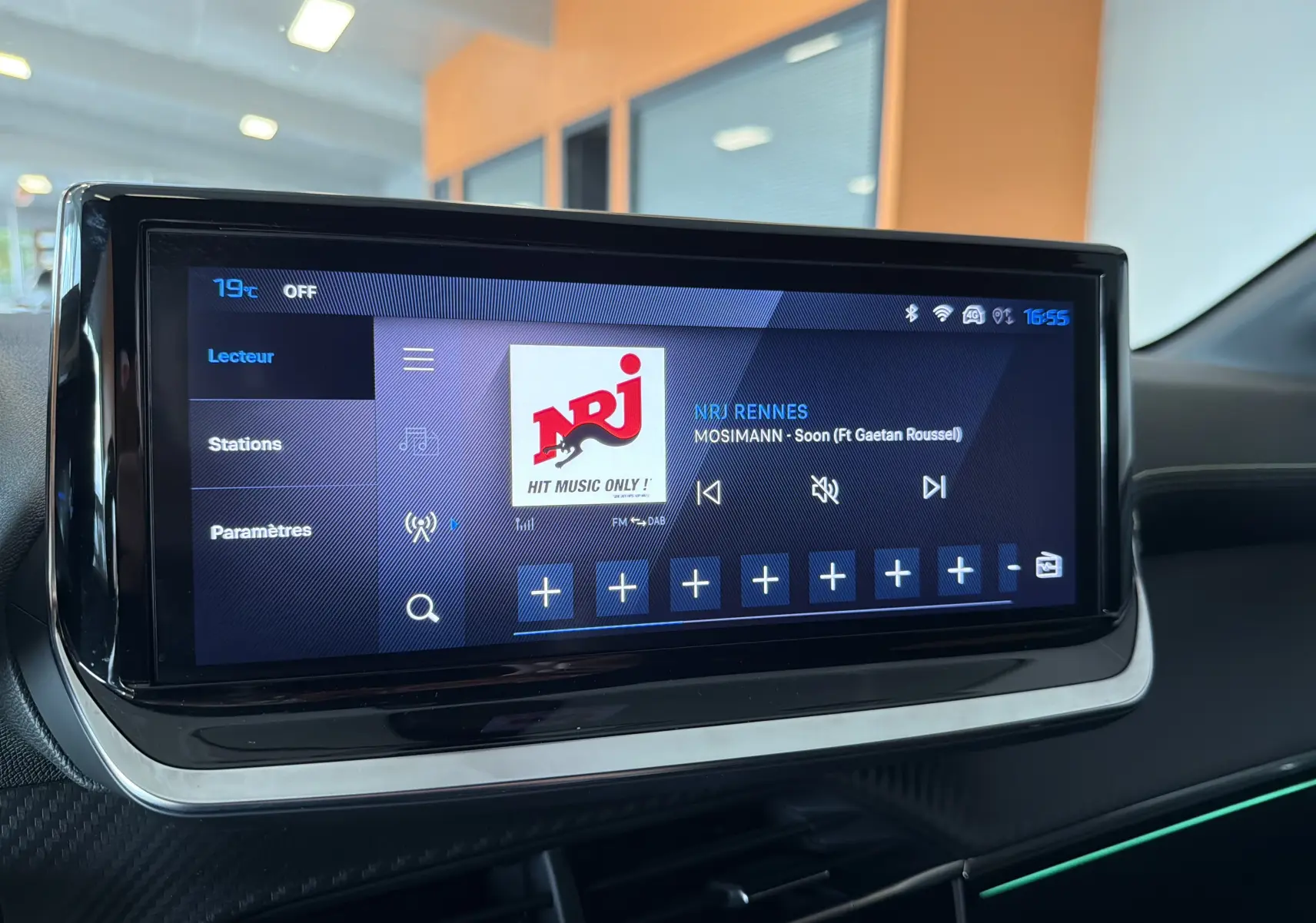 Écran tactile central du tableau de bord de la Peugeot 208 Hybrid 145 GT, affichant la radio NRJ Rennes.