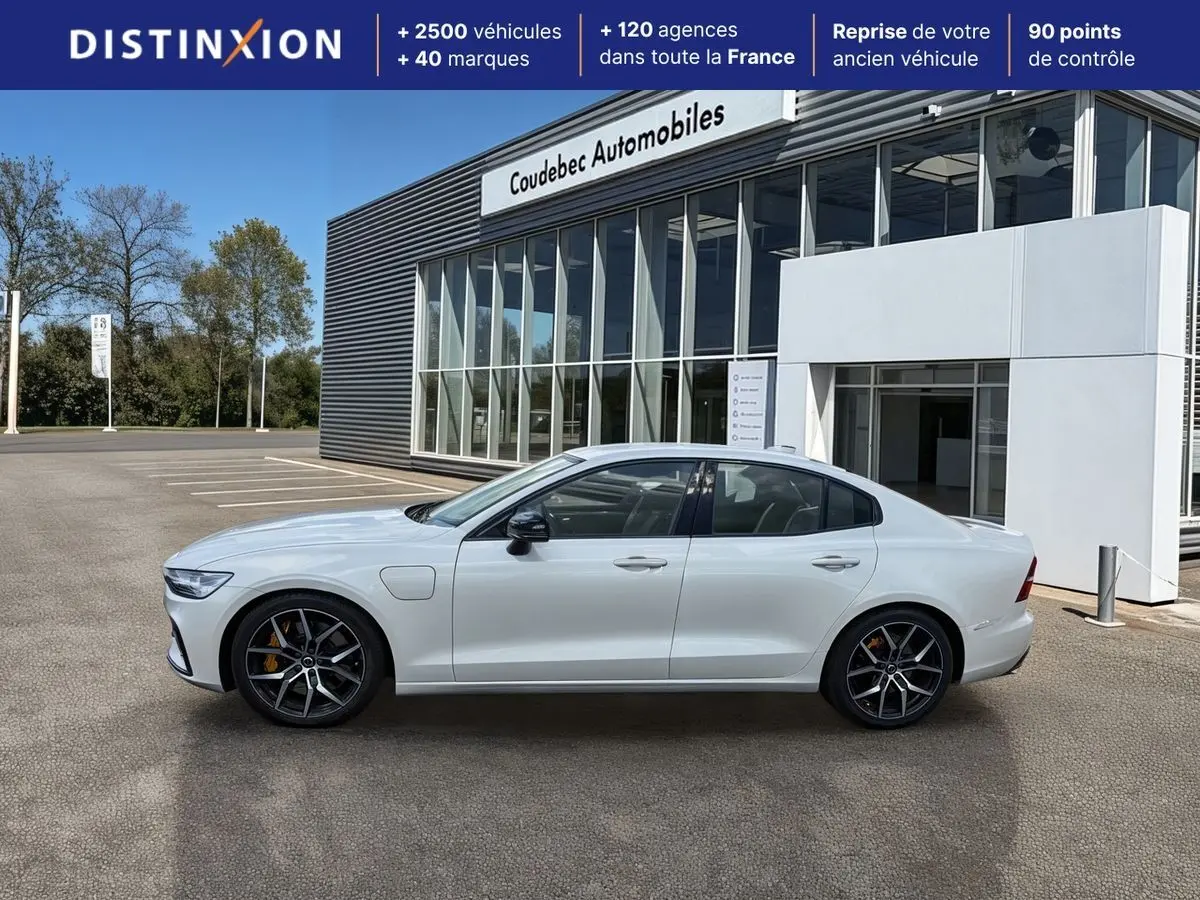 Profil droit d'une Volvo S60 T8 Twin Engine blanche, avec jantes noires à cinq branches et étriers de frein jaunes.