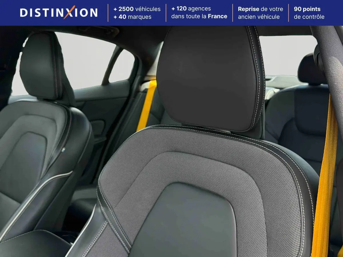 Gros plan sur les sièges avant en tissu et cuir anthracite avec ceintures de sécurité jaunes dans l'habitacle d'une Volvo S60.